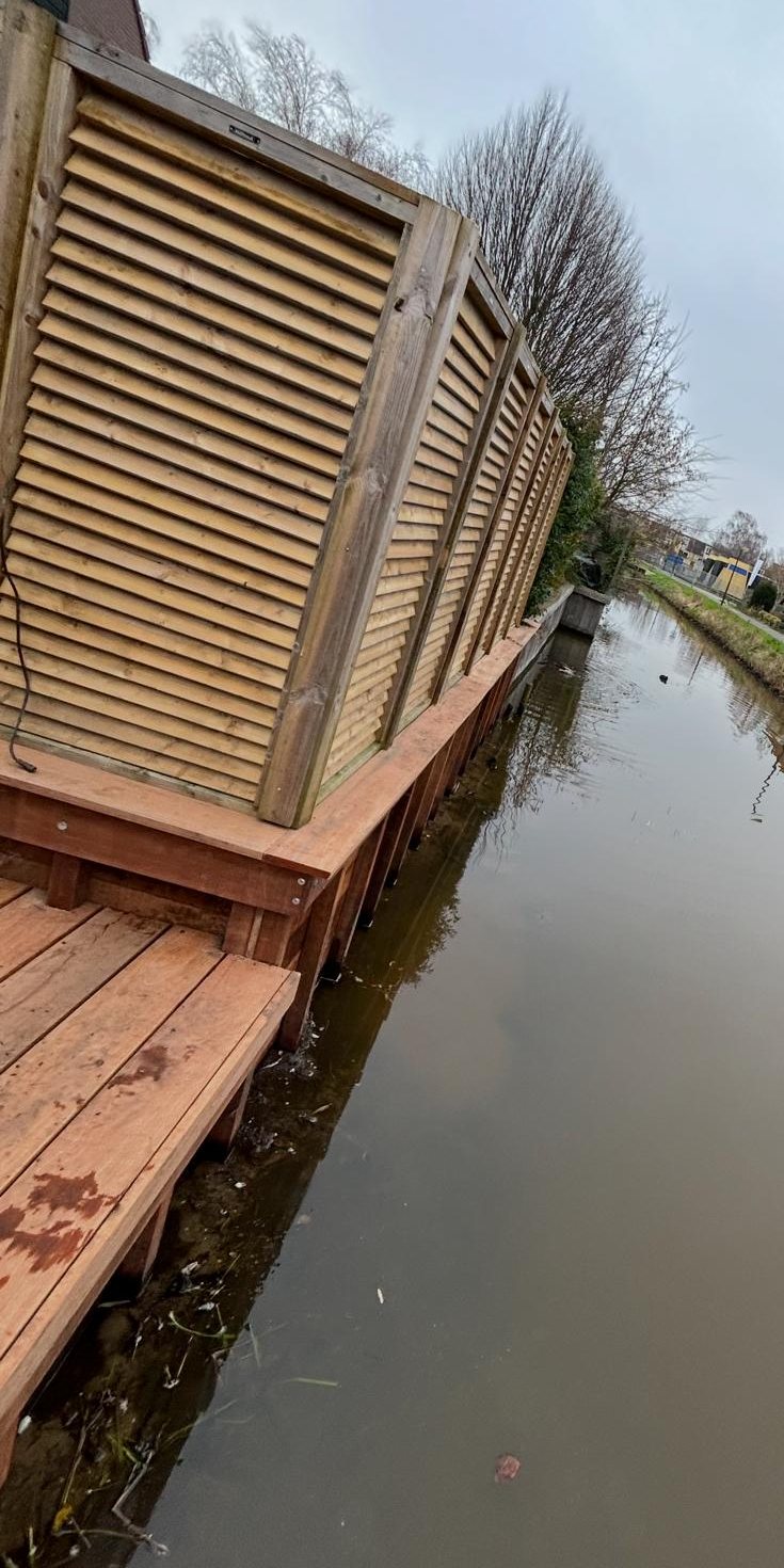 Houten vlonder met privacyscherm aan de waterkant